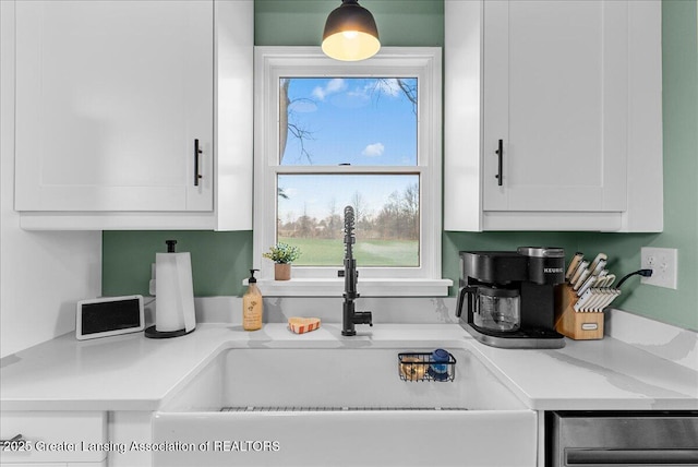 kitchen with a sink, light countertops, and white cabinets