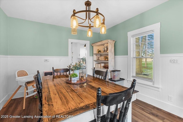 dining space with a chandelier, wood finished floors, baseboards, and wainscoting