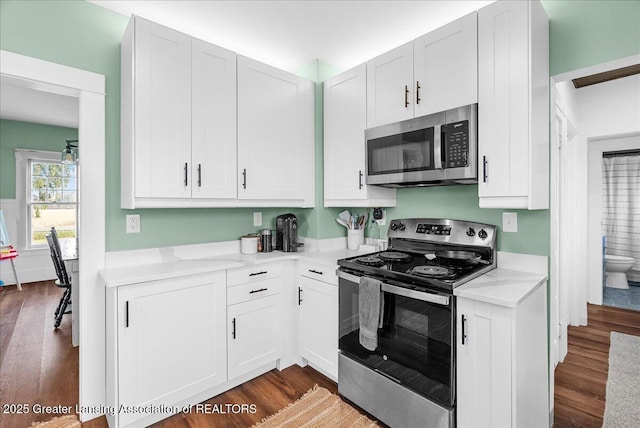 kitchen featuring dark wood-style flooring, light countertops, white cabinetry, and stainless steel appliances