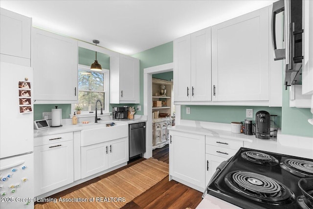 kitchen with freestanding refrigerator, dishwasher, light countertops, black electric range oven, and dark wood-style floors
