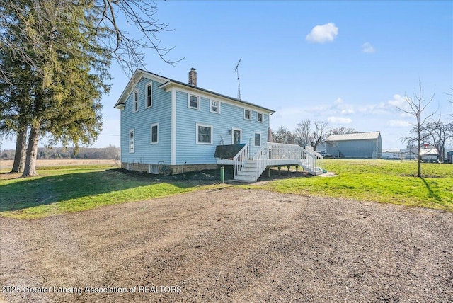 back of house featuring a yard, stairway, a deck, and a chimney