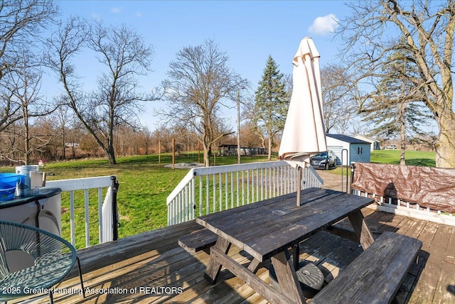 deck with an outbuilding, outdoor dining area, and a lawn