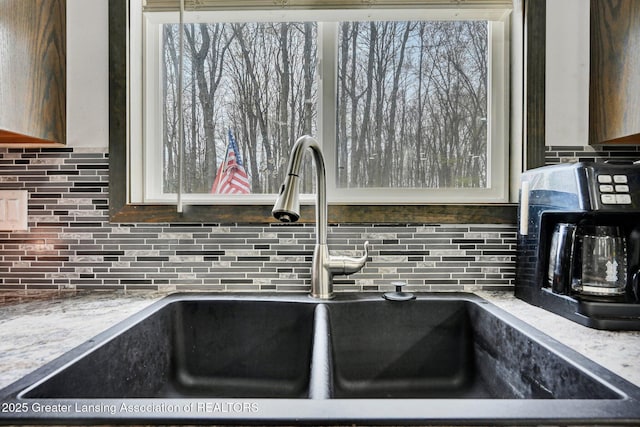 room details featuring decorative backsplash and a sink