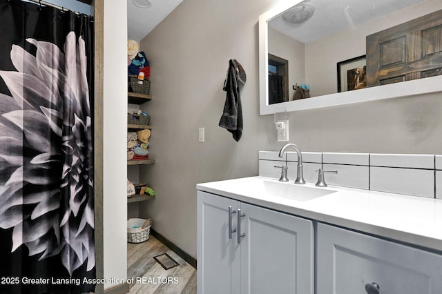 full bathroom with a shower with curtain, vanity, wood finished floors, and baseboards