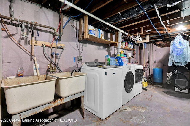 washroom with washer and clothes dryer, laundry area, and a sink