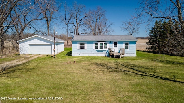 back of property with an outbuilding, a lawn, and a garage