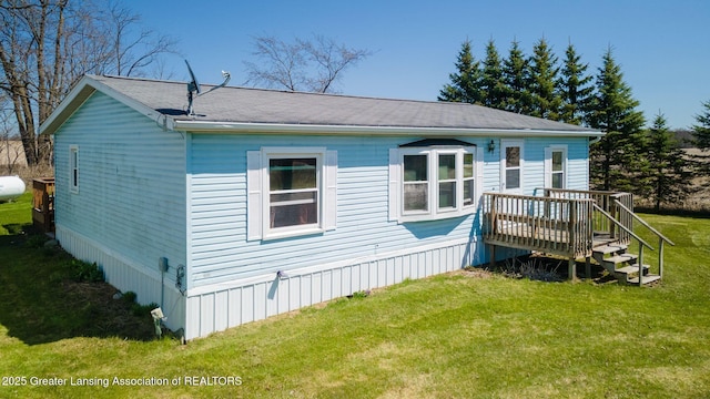 rear view of house featuring a yard and a wooden deck