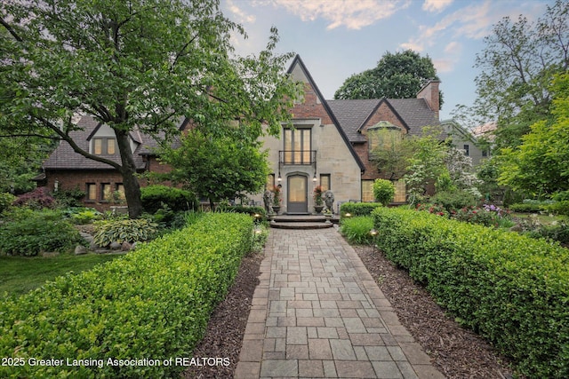 728 Audubon Rd, East Lansing, MI 48823 - tudor house featuring stone siding and a chimney
