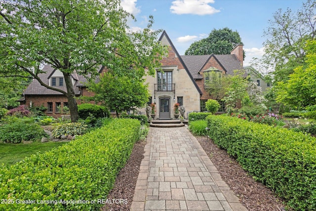 728 Audubon Rd, East Lansing, MI 48823 - tudor house featuring stone siding and a chimney