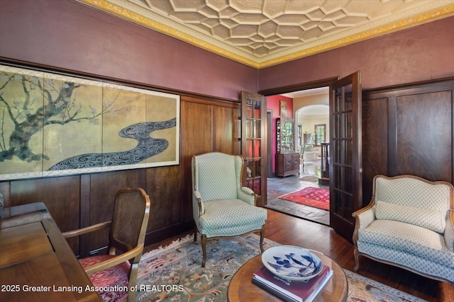728 Audubon Rd, East Lansing, MI 48823 - living area with hardwood / wood-style flooring, crown molding, coffered ceiling, and arched walkways
