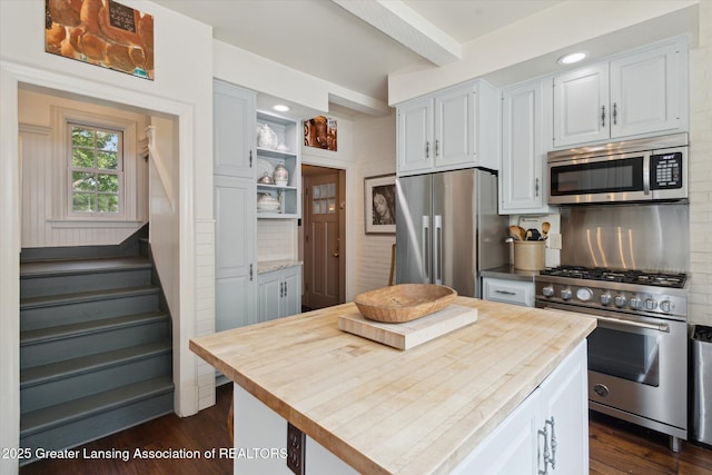 728 Audubon Rd, East Lansing, MI 48823 - kitchen with premium appliances, backsplash, dark wood-type flooring, white cabinetry, and beam ceiling