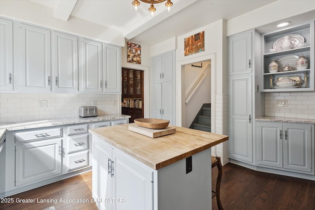 728 Audubon Rd, East Lansing, MI 48823 - kitchen with backsplash, dark wood-style floors, wooden counters, a center island, and beam ceiling