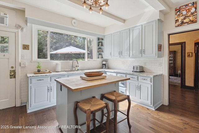 728 Audubon Rd, East Lansing, MI 48823 - kitchen featuring wooden counters, decorative backsplash, hardwood / wood-style floors, and beam ceiling