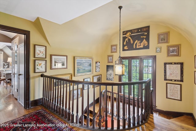 728 Audubon Rd, East Lansing, MI 48823 - stairway featuring wood finished floors, vaulted ceiling, and arched walkways