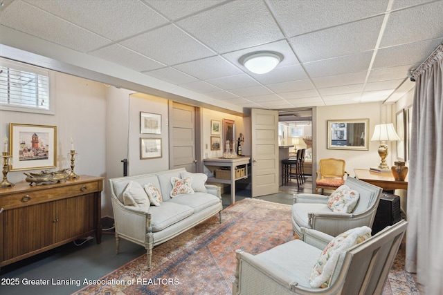 728 Audubon Rd, East Lansing, MI 48823 - living room featuring finished concrete floors and a drop ceiling