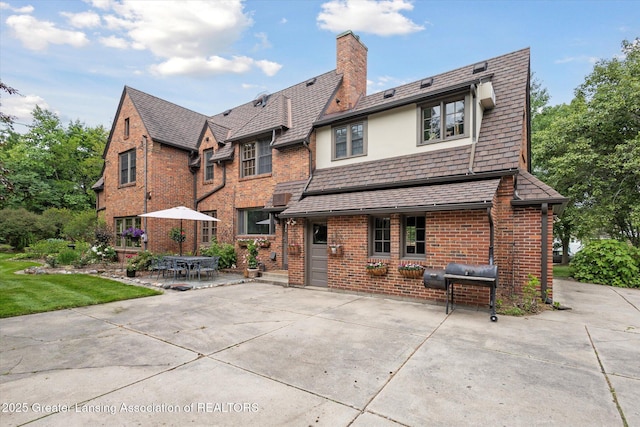 728 Audubon Rd, East Lansing, MI 48823 - back of house featuring a chimney, brick siding, and a patio area