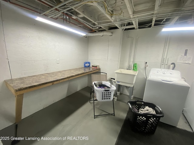below grade area featuring washer / clothes dryer and a sink