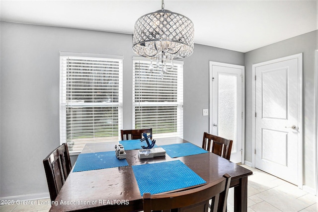 dining room featuring a chandelier, baseboards, and light tile patterned flooring