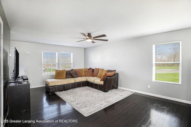 living room with baseboards, ceiling fan, and dark wood-style flooring