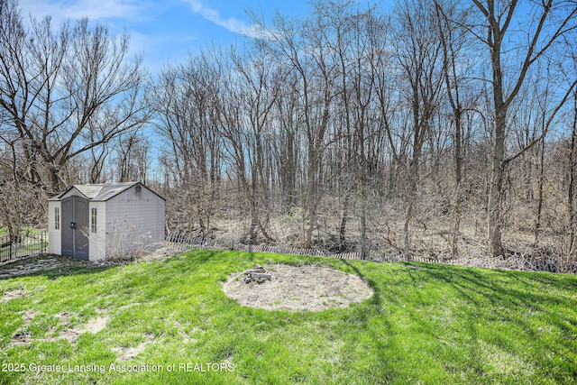 view of yard with fence, an outdoor structure, and a storage shed