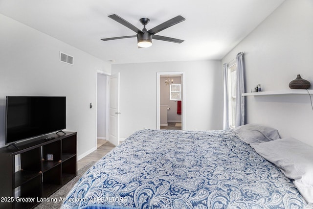 bedroom with baseboards, ensuite bath, visible vents, and ceiling fan