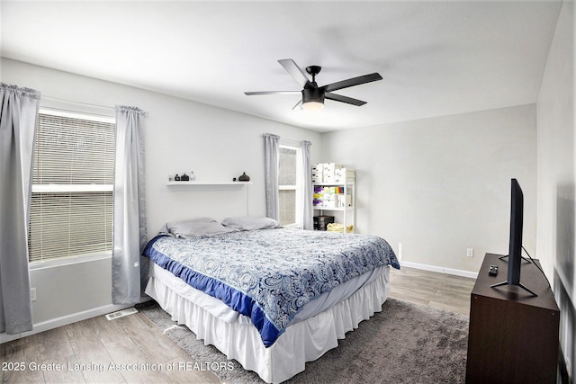 bedroom with baseboards, a ceiling fan, and light wood-style floors