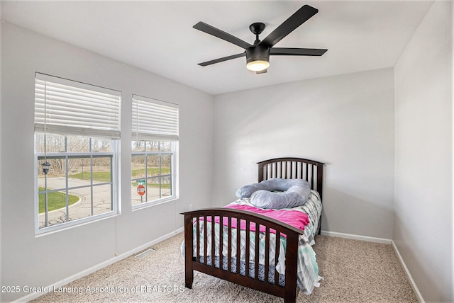 carpeted bedroom with baseboards, a ceiling fan, and visible vents