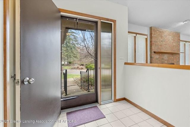 doorway to outside with tile patterned flooring and baseboards