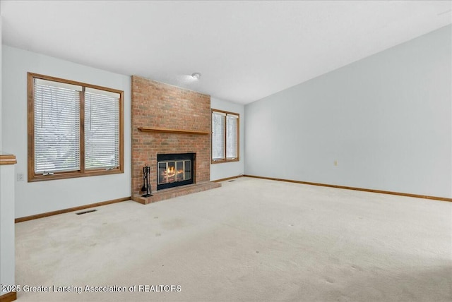 unfurnished living room with plenty of natural light, visible vents, and carpet