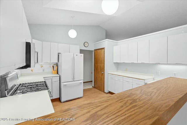 kitchen with freestanding refrigerator, light wood-style flooring, gas range oven, white cabinetry, and decorative light fixtures