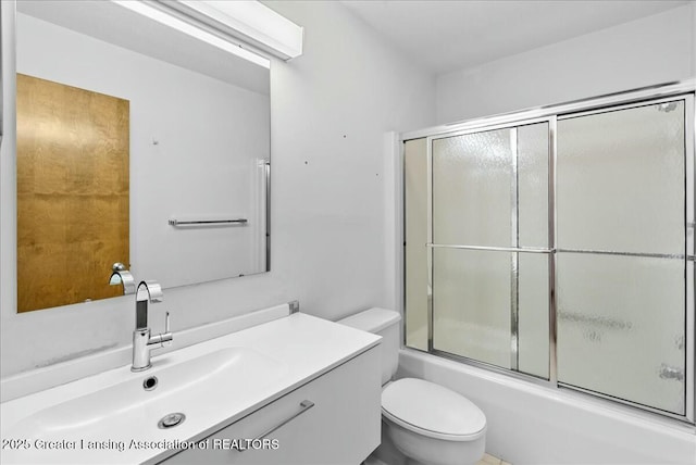 full bathroom featuring vanity, toilet, and bath / shower combo with glass door