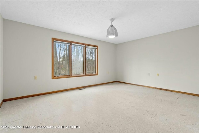 empty room featuring baseboards and visible vents
