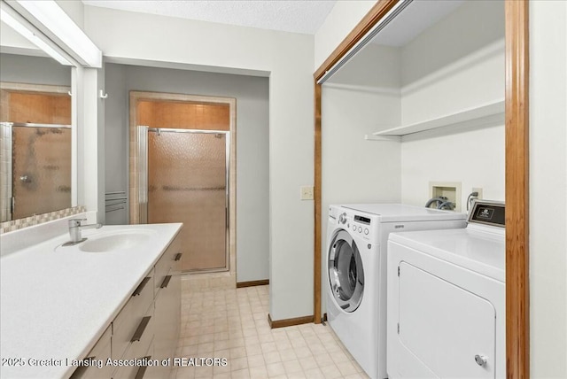 laundry area featuring laundry area, light tile patterned floors, a sink, baseboards, and separate washer and dryer