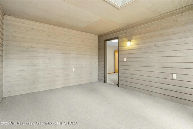 spare room with carpet floors and wooden walls