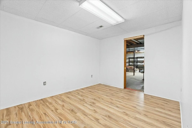 unfurnished room featuring visible vents, a paneled ceiling, and wood finished floors