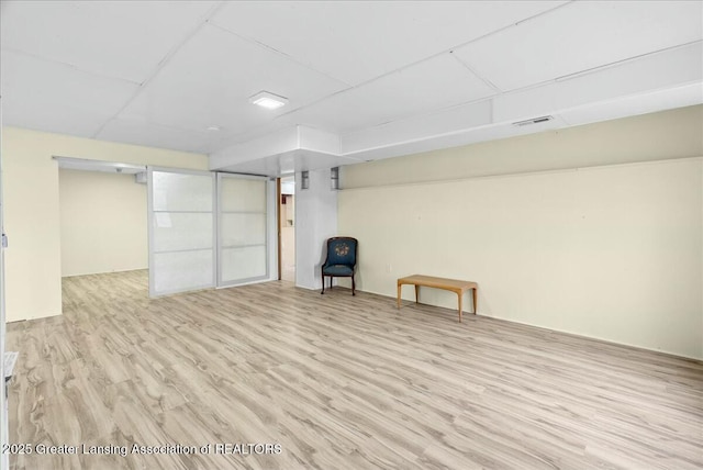 finished basement with wood finished floors and visible vents