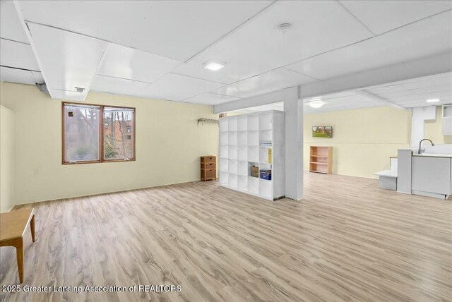below grade area with wood finished floors and a sink