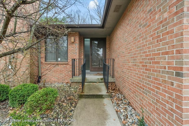 view of exterior entry featuring brick siding