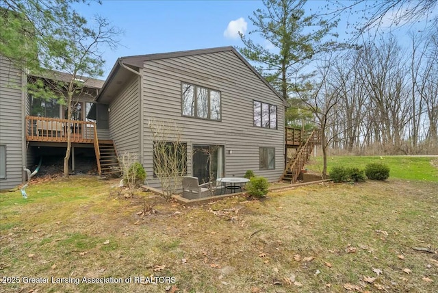 back of property featuring a yard, a deck, and stairs