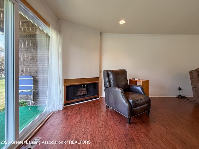 515 N Putnam St Unit B, Williamston, MI 48895 - sitting room featuring a fireplace, wood finished floors, plenty of natural light, ornamental molding, and recessed lighting