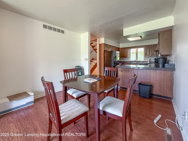 515 N Putnam St Unit B, Williamston, MI 48895 - dining space with dark wood-style flooring, stairway, and baseboards