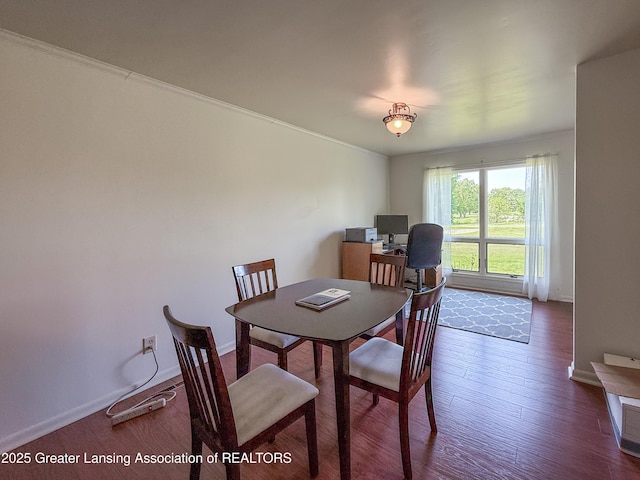 515 N Putnam St Unit B, Williamston, MI 48895 - dining area with dark wood-style flooring, baseboards, and crown molding