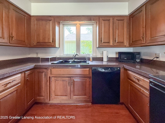 515 N Putnam St Unit B, Williamston, MI 48895 - kitchen with black appliances, a sink, brown cabinetry, and dark countertops
