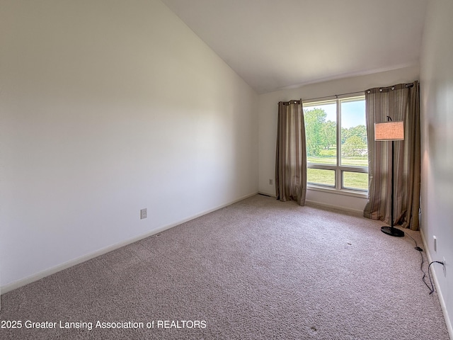 515 N Putnam St Unit B, Williamston, MI 48895 - unfurnished room featuring lofted ceiling, carpet floors, and baseboards
