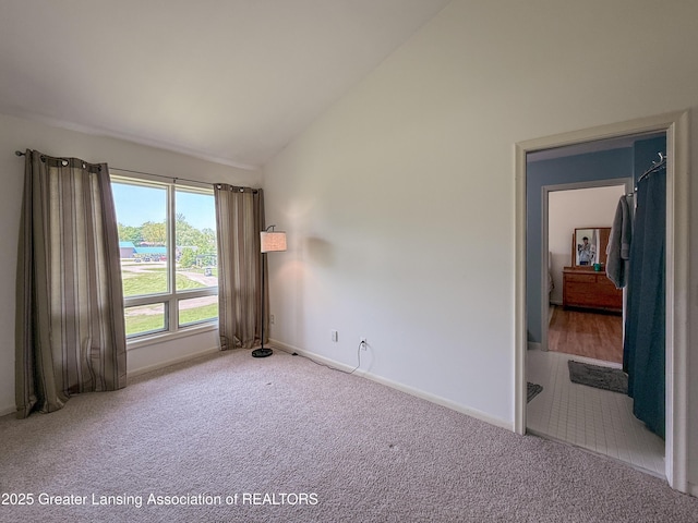 515 N Putnam St Unit B, Williamston, MI 48895 - unfurnished room with vaulted ceiling, carpet flooring, and baseboards