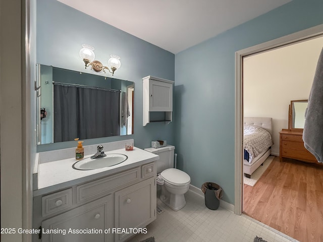 515 N Putnam St Unit B, Williamston, MI 48895 - bathroom featuring toilet, vanity, and baseboards