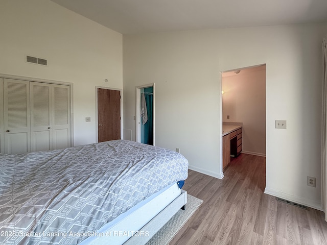 515 N Putnam St Unit B, Williamston, MI 48895 - bedroom with wood finished floors, high vaulted ceiling, and baseboards