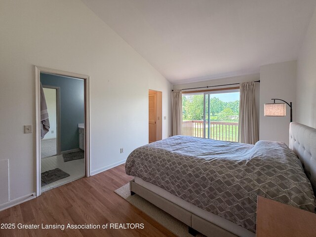 515 N Putnam St Unit B, Williamston, MI 48895 - bedroom with access to outside, wood finished floors, vaulted ceiling, and baseboards