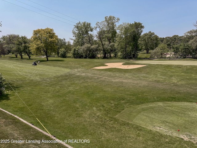 515 N Putnam St Unit B, Williamston, MI 48895 - view of community with view of wooded area, golf course view, and a lawn