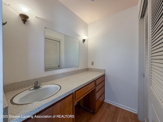 515 N Putnam St Unit B, Williamston, MI 48895 - bathroom with wood finished floors, vanity, and baseboards